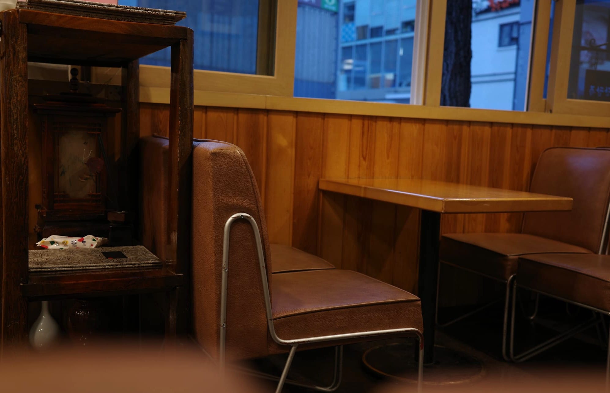 Interior shot of the teahouse showcasing the leather seats with chrome frames and small tables.