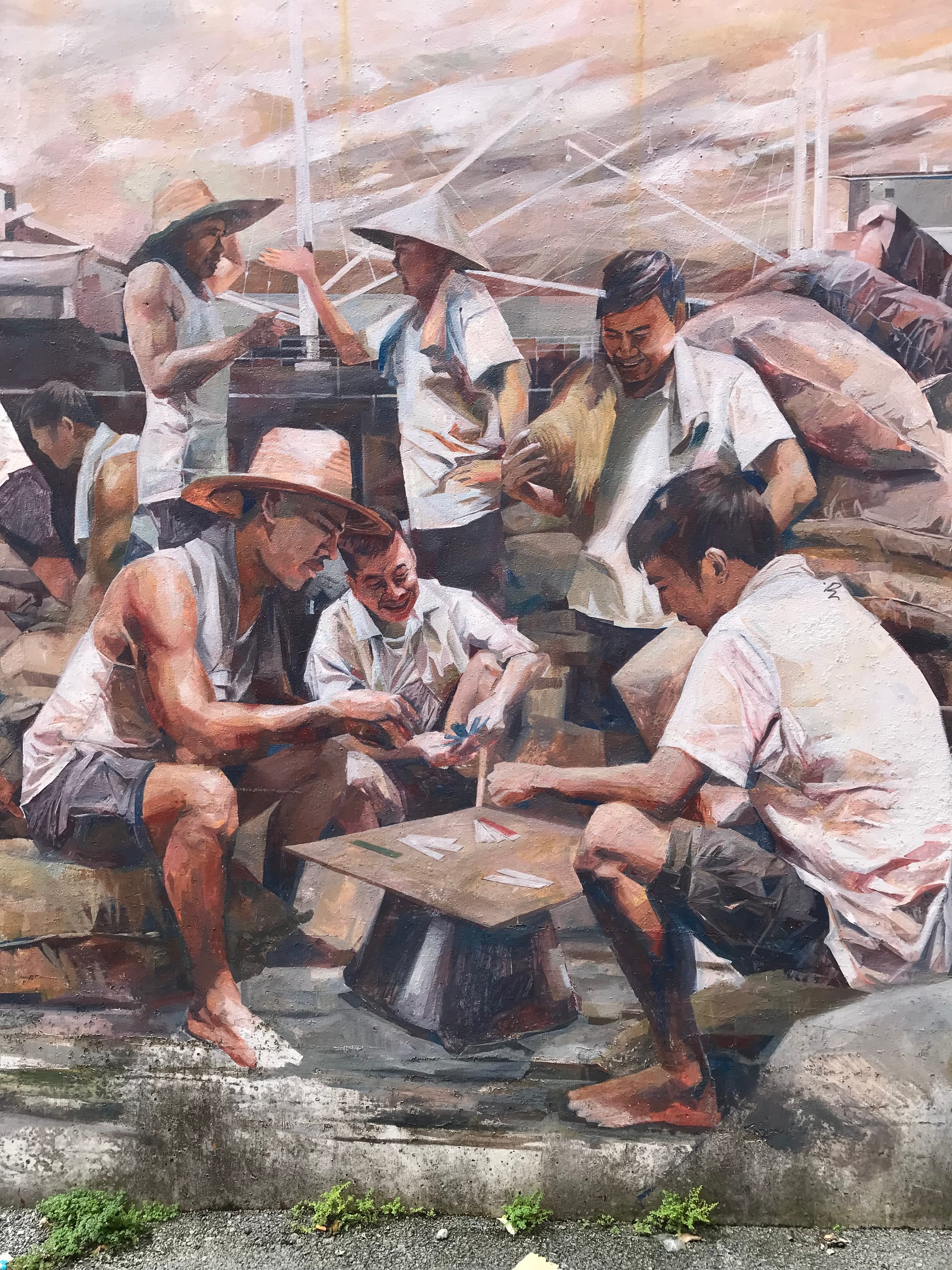 Mural of labourers playing cards with one man watching them and two men in the background arguing.