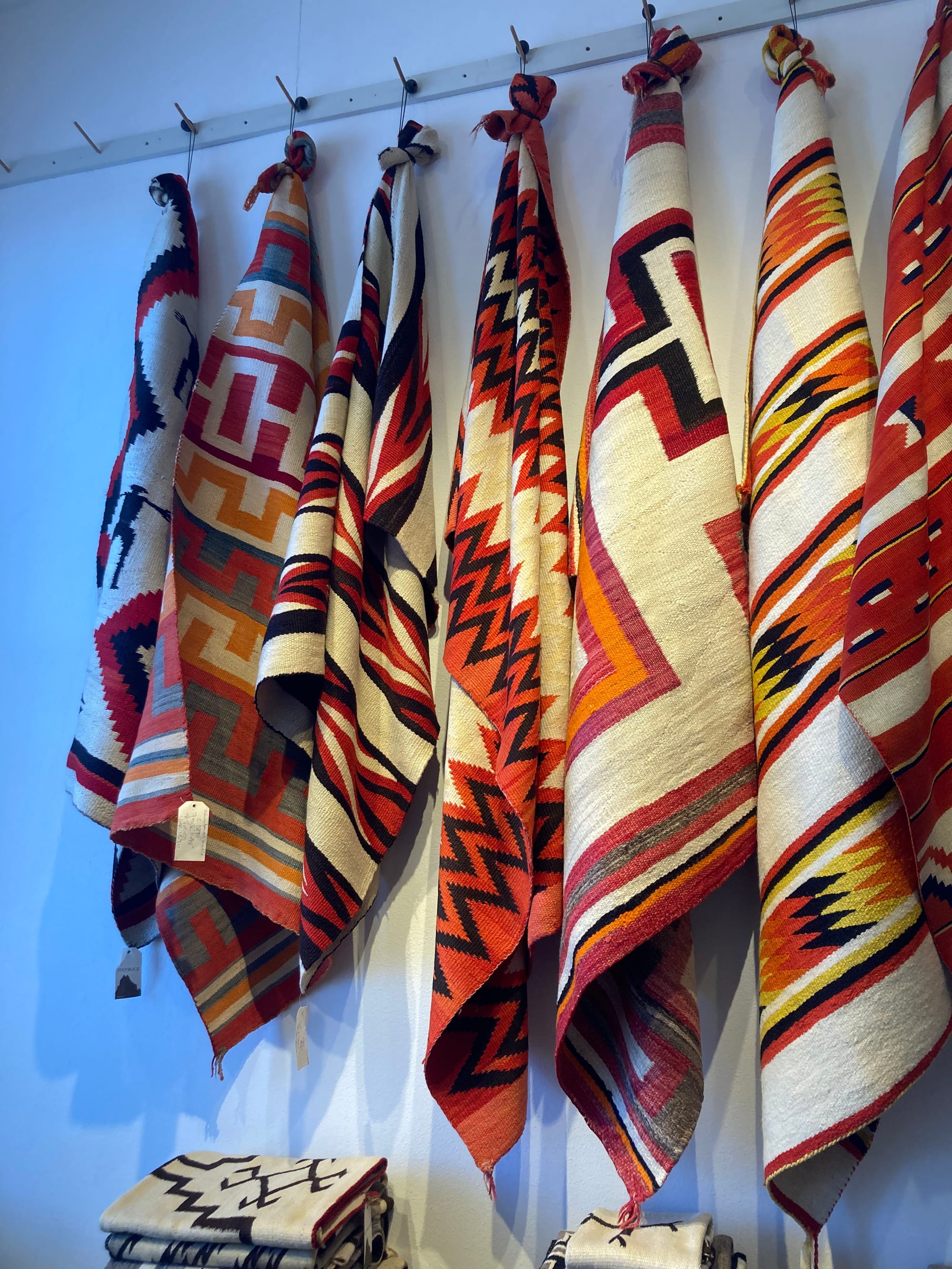 Red, white  and black Navajo rugs hung on a wall