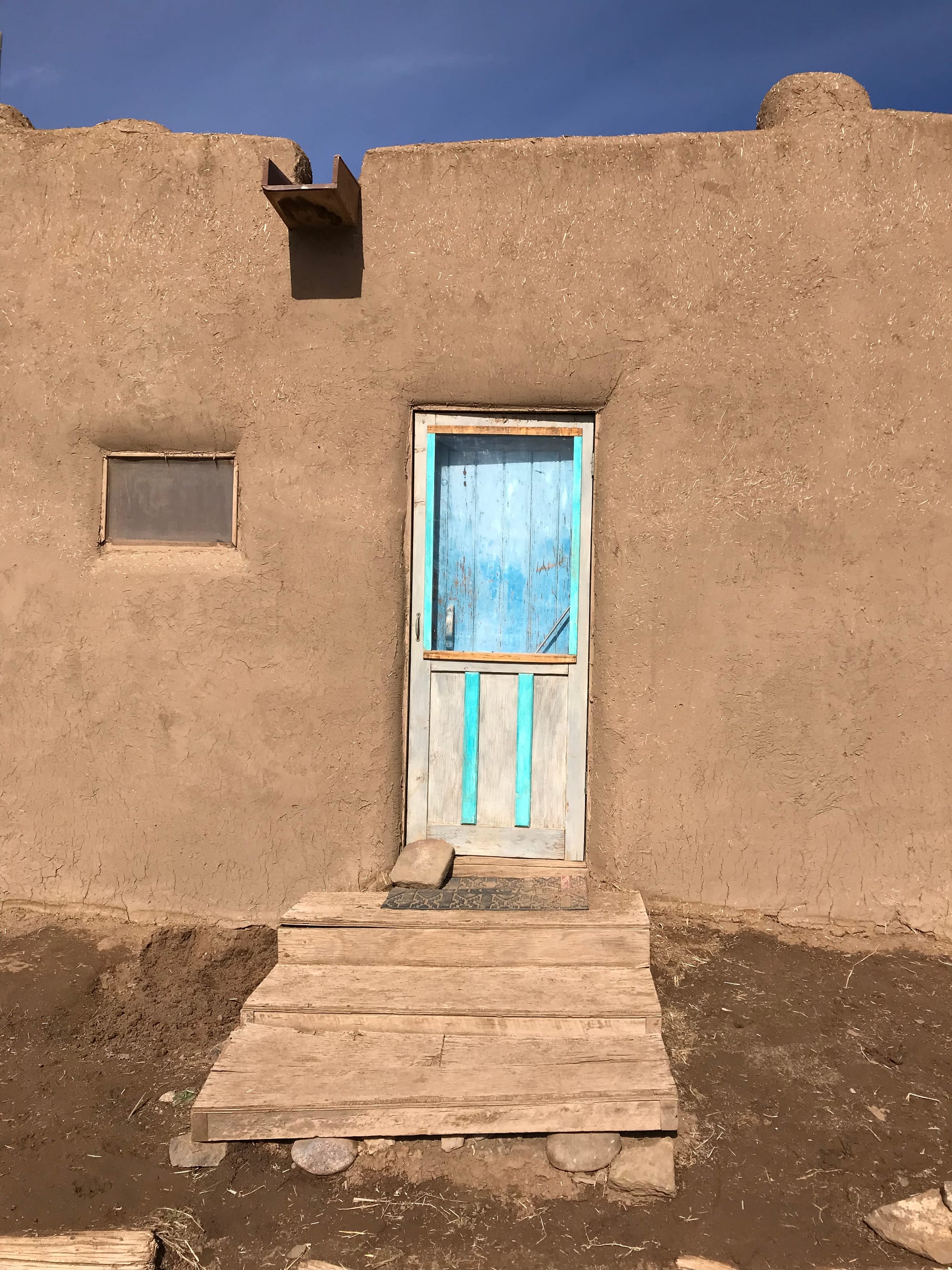 A front door to one of the north houses painted in faded turquoise.