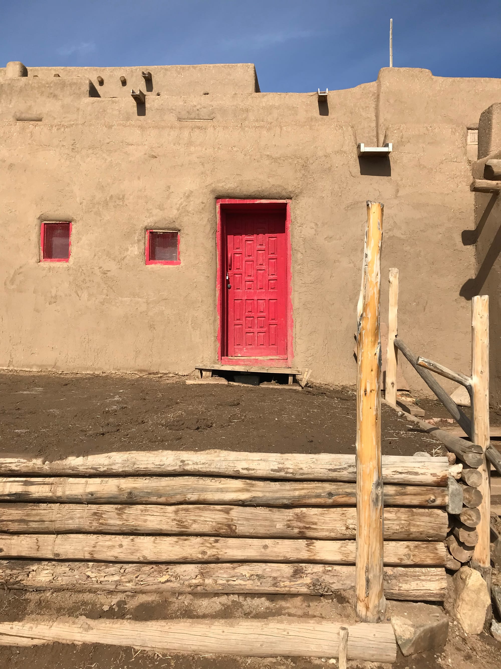 A red front door and two small red windows at the north houses.