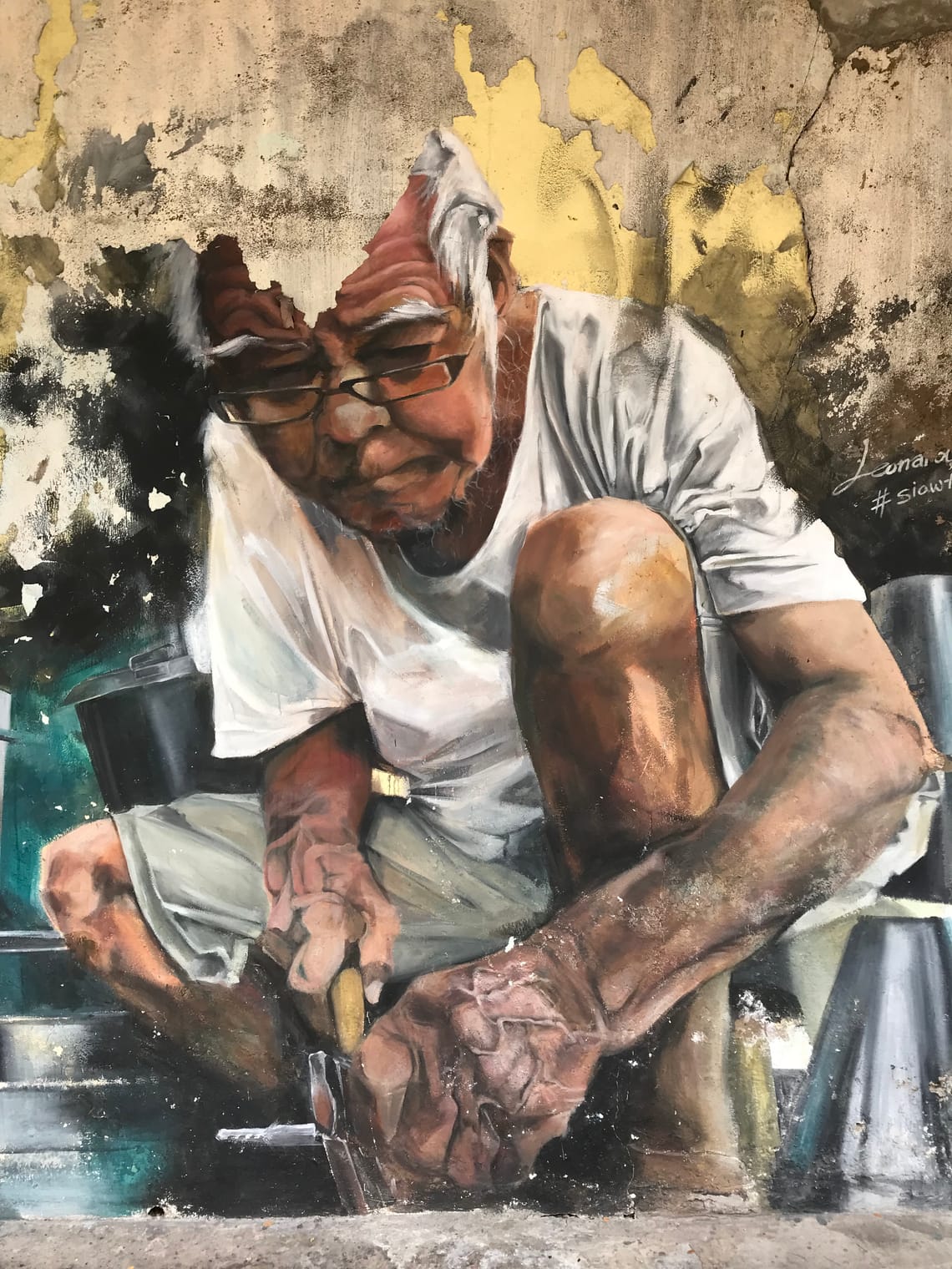 A mural of a old tin worker working